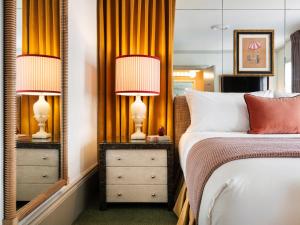 a bedroom with a bed and two lamps and a mirror at The Hotel Lili in Los Angeles
