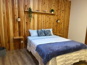 a bedroom with a large bed with wooden walls at Central House in Ribeira Grande