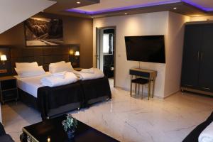 ein Hotelzimmer mit zwei Betten und einem Flachbildfernseher in der Unterkunft NRING VILLA Adenau in Adenau