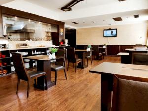 a restaurant with tables and chairs and a tv on the wall at Smith Hotel in Baku