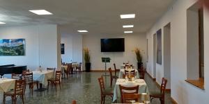 a dining room with tables and chairs and a flat screen tv at vitalArmonie Retreat in Marzio