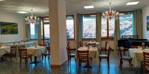 a dining room with tables and chairs and windows at vitalArmonie Retreat in Marzio