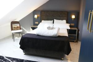 ein Schlafzimmer mit einem großen Bett und weißen Kissen in der Unterkunft NRING VILLA Adenau in Adenau