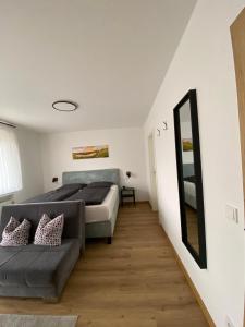 a bedroom with a bed and a couch and a mirror at Weingut Lehnert-Später in Piesport