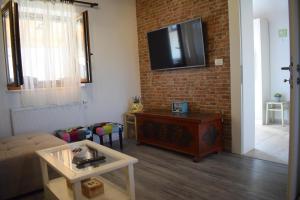 a living room with a couch and a tv on a brick wall at Villa Marko in Ljubitovica