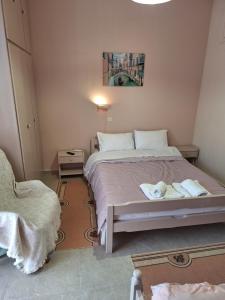 a bedroom with a bed with two towels on it at ILIANA apartments in Preveza