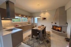a kitchen with a dining table and a fireplace at Villa Lonaki in Haraki