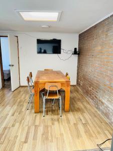 a table and chairs in a room with a brick wall at Departamento Independiente Altavista Hostal- 6 personas in Rancagua