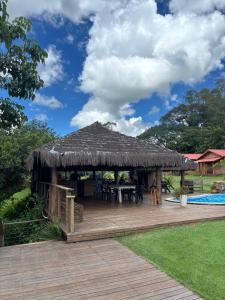 a wooden gazebo with a table and a roof at Estância da Mata in CÃ¡ssia