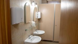 a bathroom with two sinks and a shower and mirrors at Valmiera Park Hostel in Valmiera