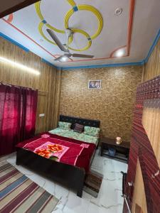 a bedroom with a bed and a ceiling with a chandelier at Naimisharanya Residency in Naimishāranya