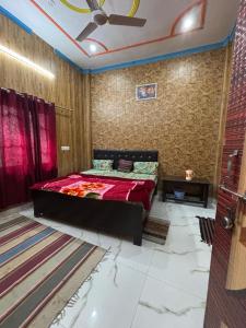 a bedroom with a bed and a ceiling fan at Naimisharanya Residency in Naimishāranya