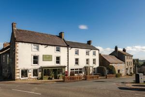 a large white building on the side of a street at The Wensleydale Hotel in Middleham