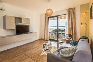 a living room with a couch and a tv at Villa REANA in Brela