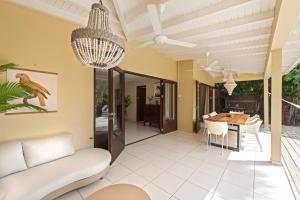 a living room with a chandelier and a table at Villa The Hidden Palm, Piscadera, Private Pool in Willemstad