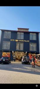 a hotel building with cars parked in front of it at Hotel Crown Palace in Dunga Gali