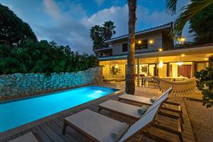 a villa with a swimming pool at night at Villa The Hidden Palm, Piscadera, Private Pool in Willemstad