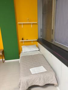 two beds in a room with yellow and green walls at Loft 80 in Castel Maggiore