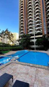 an empty swimming pool in front of two tall buildings at Alphaville Serviced Apartment São Paulo in Barueri