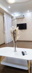 a vase of dried flowers sitting on a white table at Old Town Apartment in Tashkent