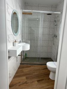 a bathroom with a shower and a sink and a toilet at Central House in Ribeira Grande +46 photos