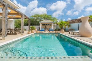a swimming pool with a patio and a gazebo at Vista Alegre by Boutique Bonaire Unique Resorts in Kralendijk