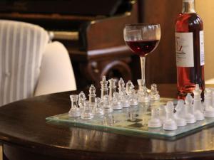 a glass of wine next to a chess board and a bottle of wine at Landhaus Victoria in Boltenhagen