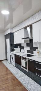 a kitchen with white appliances and white cabinets at Old Town Apartment in Tashkent