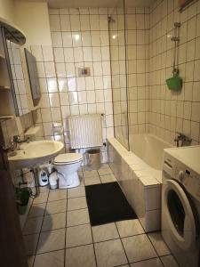 a bathroom with a sink and a toilet and a tub at My Apartments&Rooms 04 in Gelsenkirchen +49 photos
