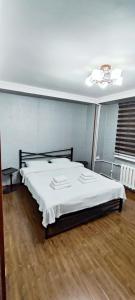 a bedroom with a bed with white sheets and a ceiling at Old Town Apartment in Tashkent