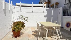 a table and chairs on a patio with a potted plant at TarifaMiCasa Mar Tirreno in Tarifa