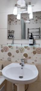 a bathroom with a white sink and a mirror at Old Town Apartment in Tashkent +35 photos
