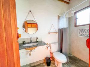 a bathroom with a toilet and a sink and a mirror at Sítio Embaú in Carrancas +30 photos