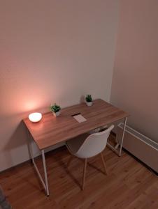 a wooden desk with a chair and a light on it at Google Smart Home Unterkunft - 1 in Kenn +1 photo