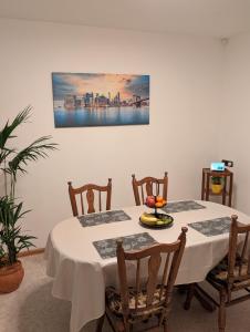 a dining room table with chairs and a painting on the wall at Google Smart Home Unterkunft - 1 in Kenn