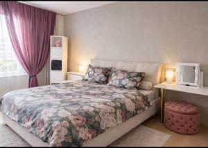 a bedroom with a bed with a floral bedspread at OzolApart Lux in Jēkabpils