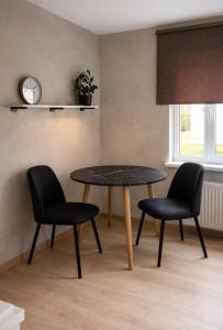 a dining room with a table and two chairs at OzolApart Lux in Jēkabpils