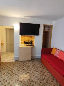 a living room with a red couch and a kitchen at Cefalhub in Cefalù