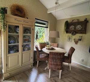 a dining room with a table and a china cabinet at Hof van Benten in Ermelo