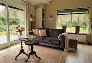 a living room with a purple couch and a table at Hof van Benten in Ermelo