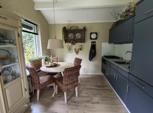a kitchen with a table and chairs and a sink at Hof van Benten in Ermelo