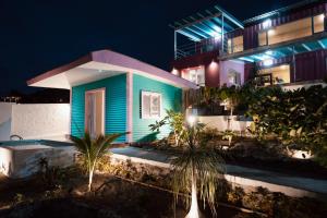 ein Haus mit blauem Gebäude und Palmen bei Nacht in der Unterkunft Flamingo Beach Santa Marianita Manta in Manta