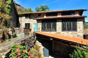 a stone house with a bridge in front of it at Casa Yañez in Chantada
