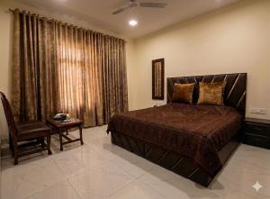 a bedroom with a bed and a chair and a window at The Meer Mansion in Srinagar