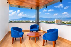 two chairs and a table in a room with a large window at Vitash Inn in Tirupati