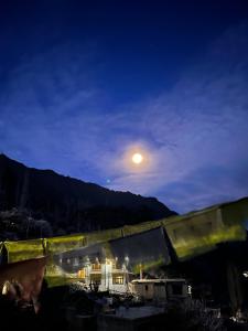 a view of a building at night with the moon at Dosho pa in Dah