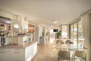 a kitchen with white cabinets and a table and chairs at Hotel Sanremo in Caorle