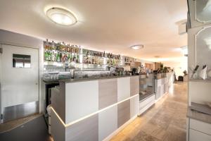 a kitchen with a counter with alcohol bottles at Hotel Sanremo in Caorle +26 photos