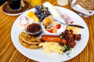 a plate of breakfast food on a wooden table at Rév-Panzió in Abádszalók