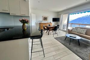 a kitchen and living room with a table and a couch at Ferienwohnung C15 in Orselina